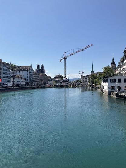 Blick von weiter weg auf Fluss und Brücke mit Kran