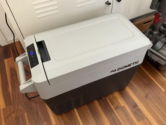 Photo of a Dometic CFF 20 mobile compressor cooler, a gray box with a lid and a display showing “20 °C.”